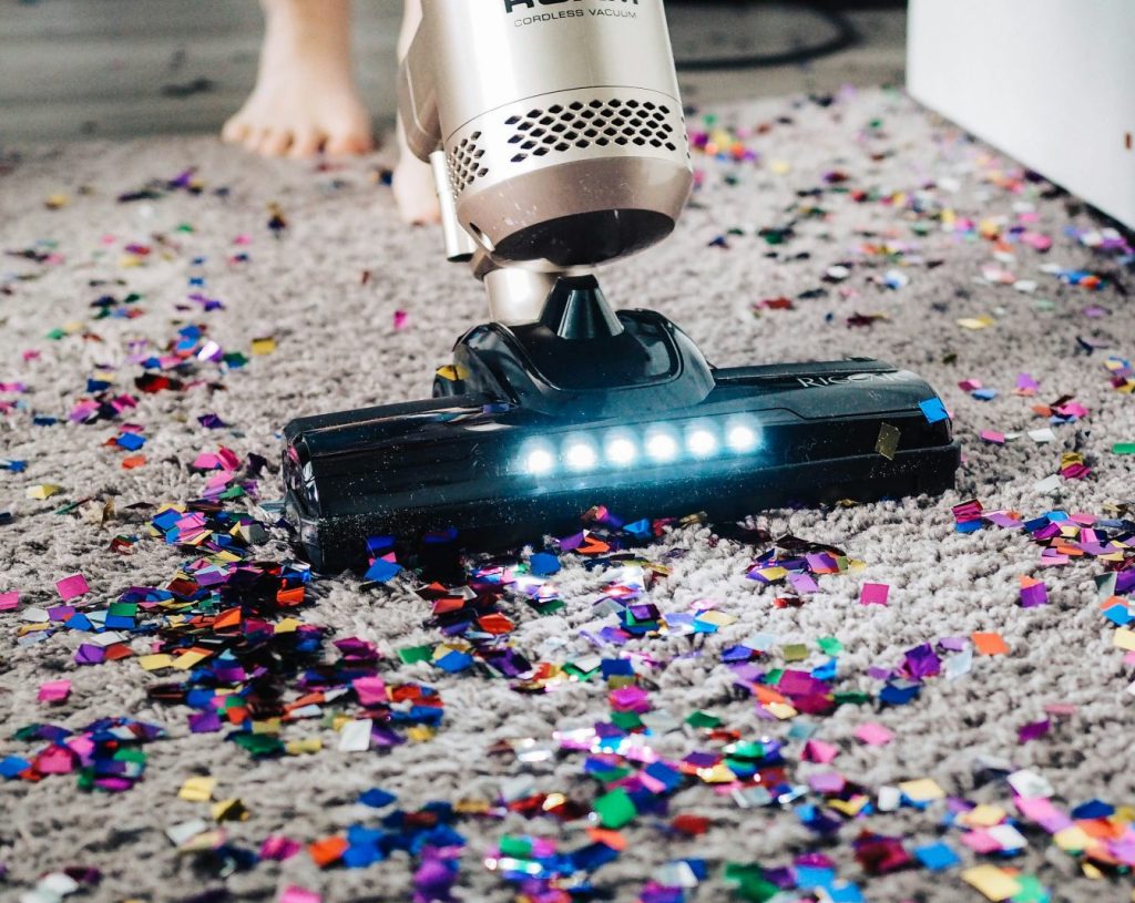 a person using a vacuum to clean a carpet